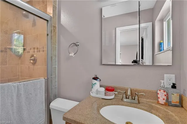 a bathroom with a sink vanity mirror and toilet