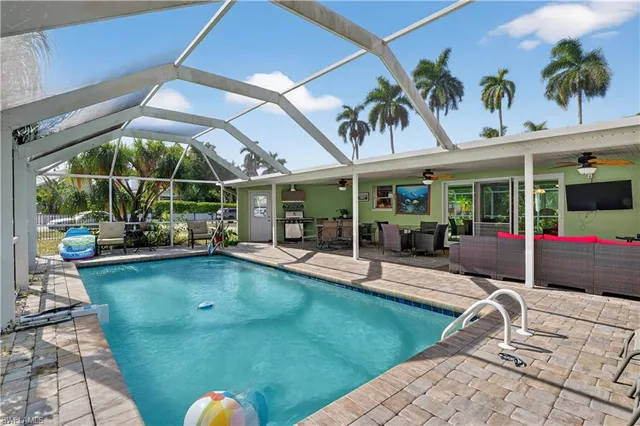 a view of a backyard with swimming pool and sitting area