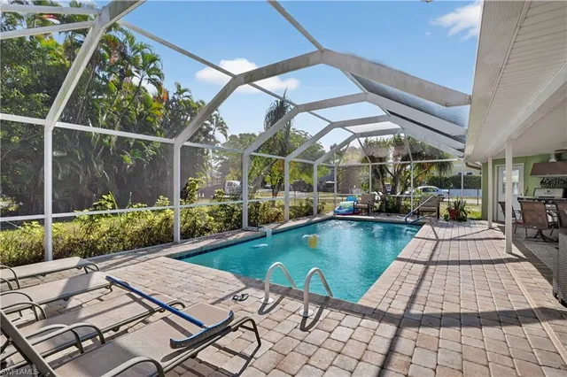a view of swimming pool with seating space and wooden fence