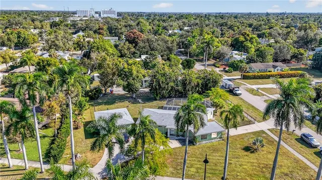 an aerial view of residential houses with outdoor space and trees