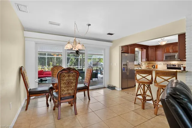a dining room with furniture a chandelier and window