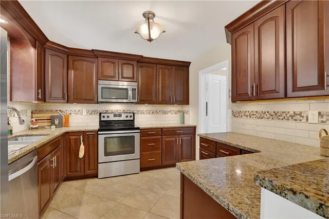 a kitchen with stainless steel appliances granite countertop a sink stove and microwave