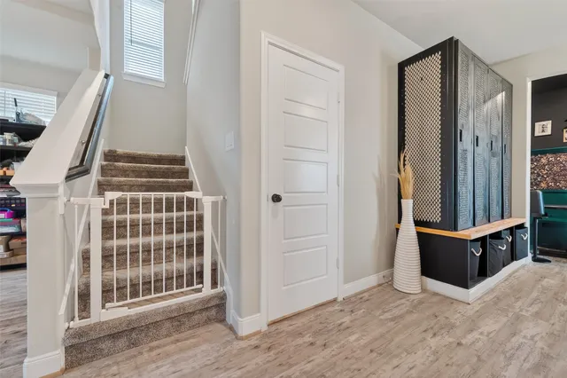 an entryway with wooden floor and staircase