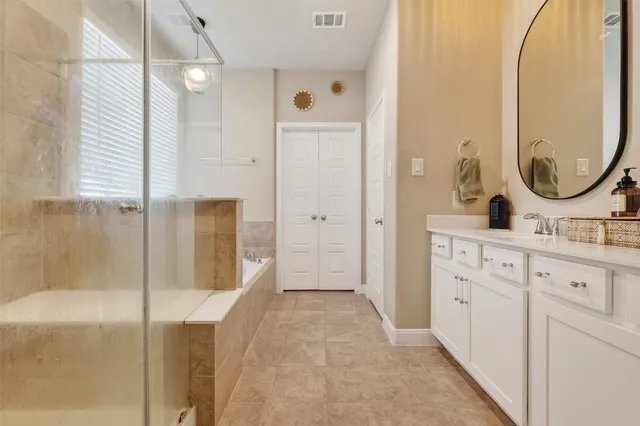 a bathroom with a double vanity sink mirror and shower