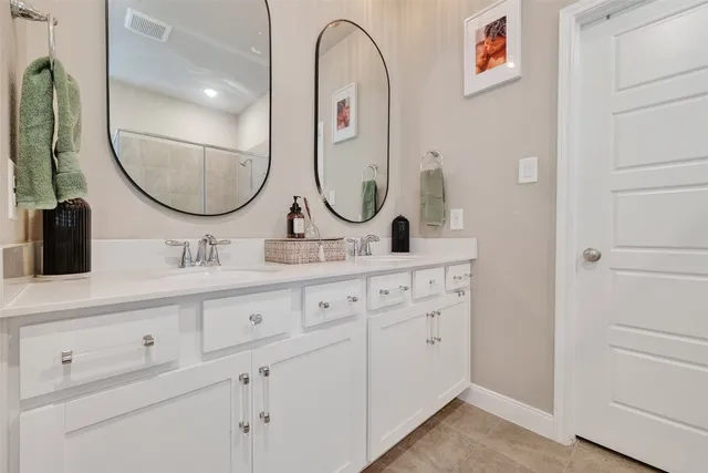 a bathroom with a double vanity sink and a mirror