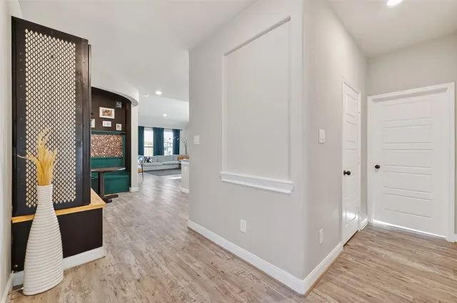 a view of a hallway with wooden floor and furniture