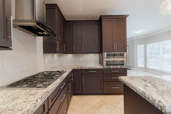a kitchen with stainless steel appliances granite countertop a sink and a stove