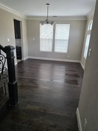 a view of a room with wooden floor chandelier and entryway