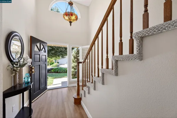 a view of a hallway with wooden floor and entryway