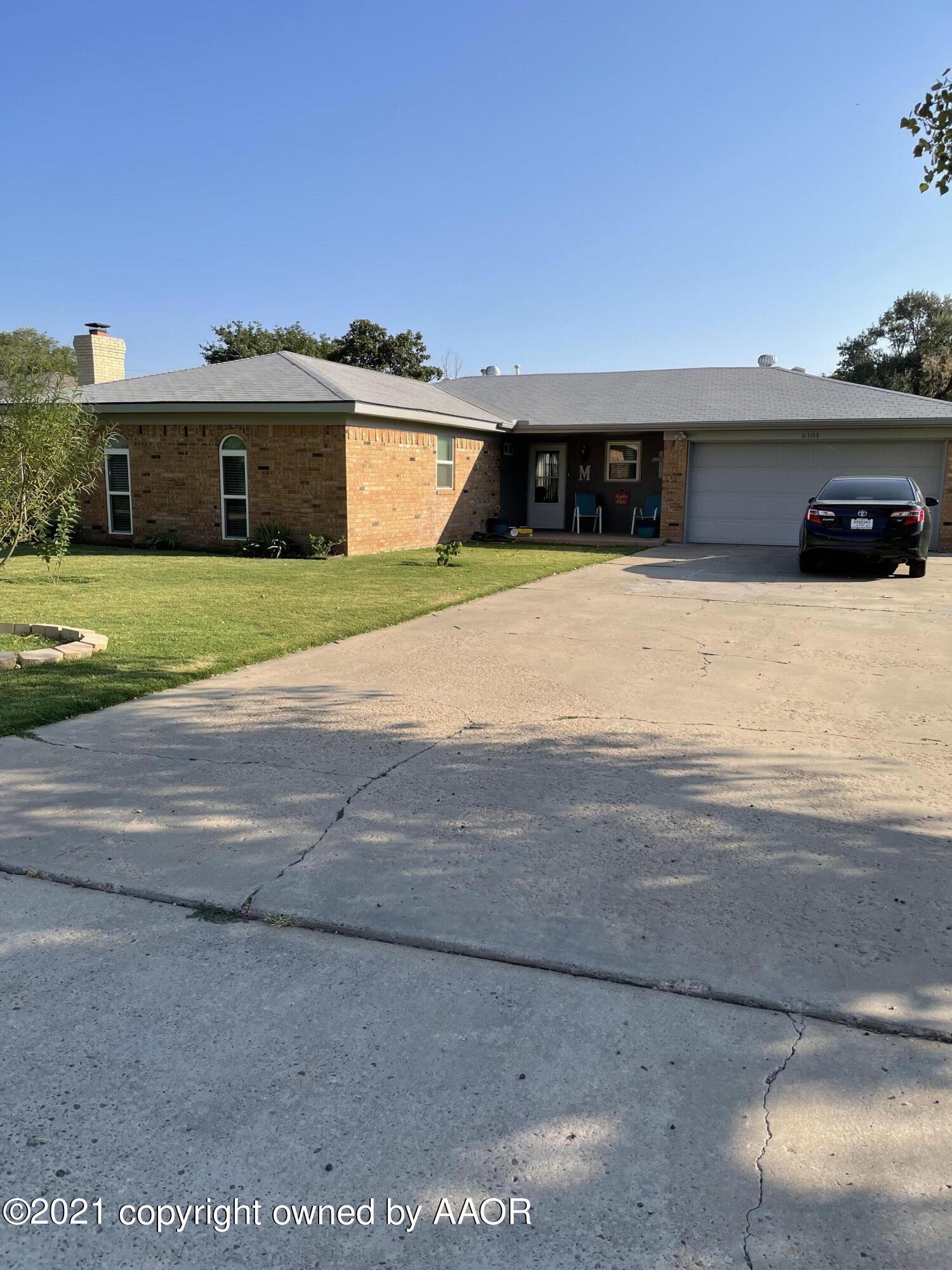 6101 Shawnee Trail Amarillo, TX 79109 - Photo 2 of 20 a front view of a house with a yard and a garage