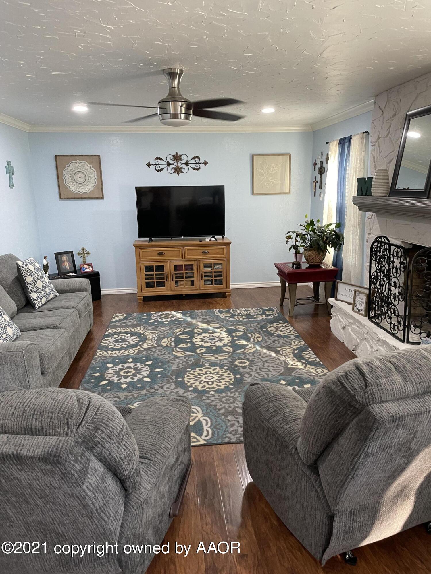 6101 Shawnee Trail Amarillo, TX 79109 - Photo 4 of 20 a living room with furniture a flat screen tv and a fireplace