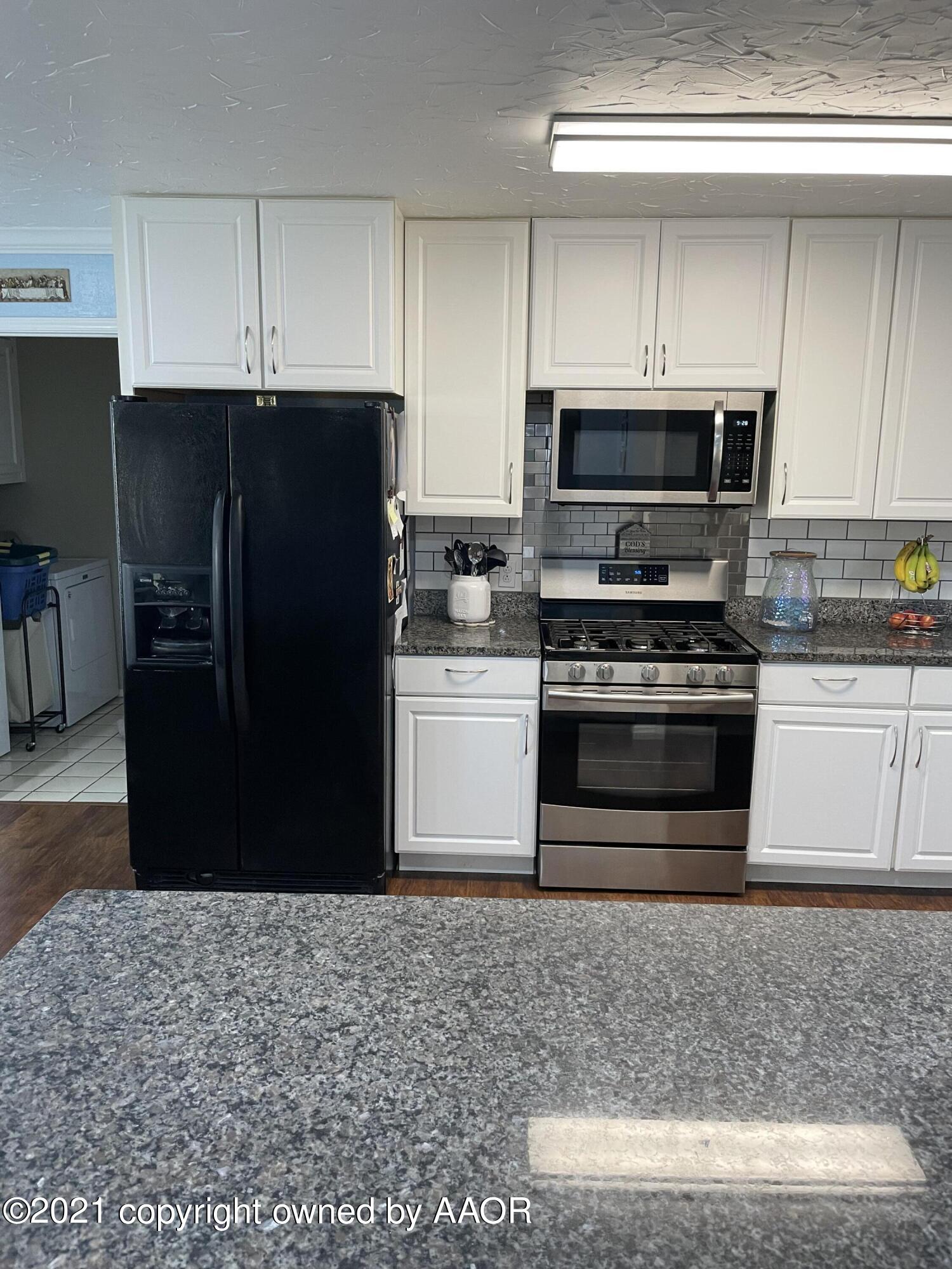 6101 Shawnee Trail Amarillo, TX 79109 - Photo 8 of 20 a kitchen with stainless steel appliances kitchen island granite countertop a refrigerator stove and oven