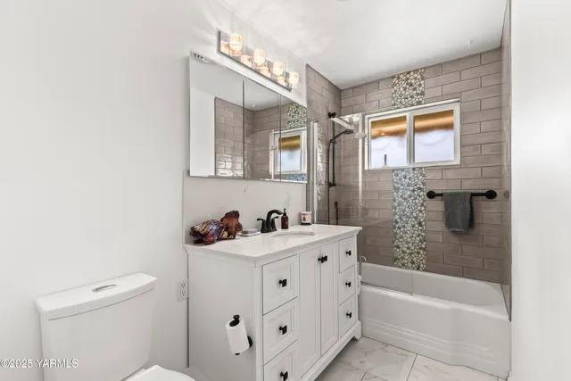 a bathroom with a sink toilet vanity and bathtub