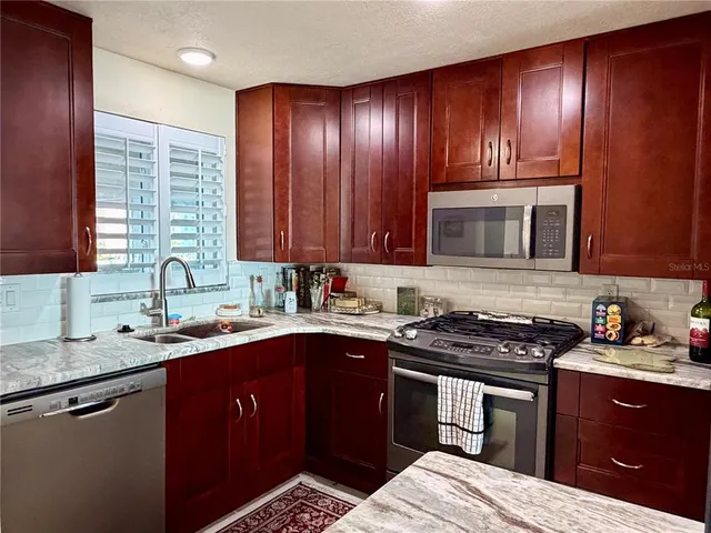 a kitchen with wooden cabinets and a stove top oven