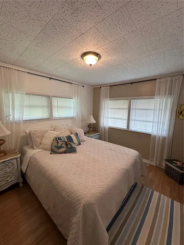 a bedroom with a bed and large windows