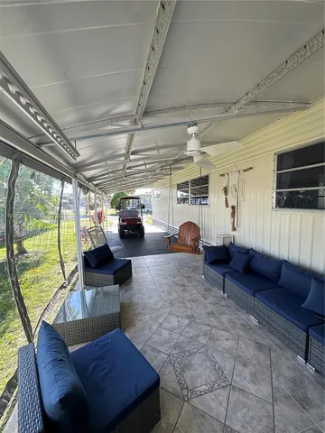 a living room with furniture a flat screen tv and a window