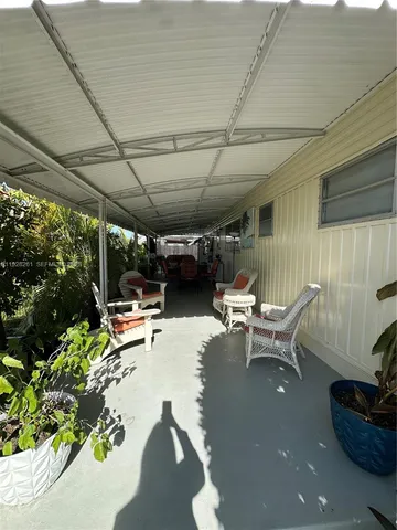 a view of a patio with table and chairs potted plants with wooden floor