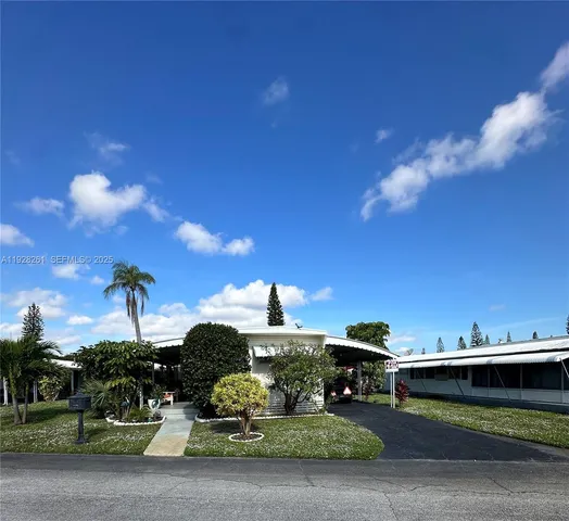 a view of a house with a yard and potted plants
