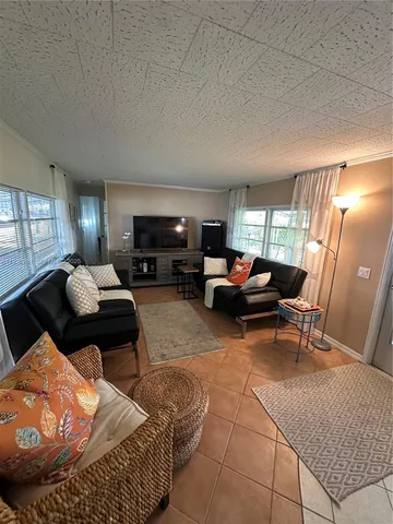 a living room with furniture a flat screen tv and a table