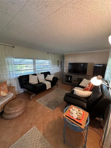 a living room with furniture a flat screen tv and a window