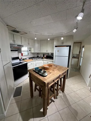 a kitchen with a table chairs and a refrigerator