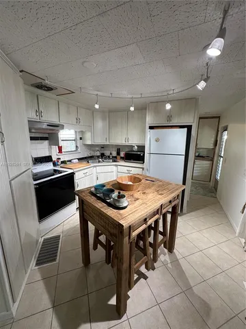 a kitchen with a table chairs sink and cabinets
