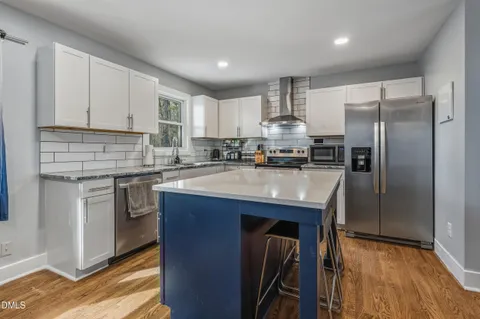 a living room with furniture and a dining table with wooden floor