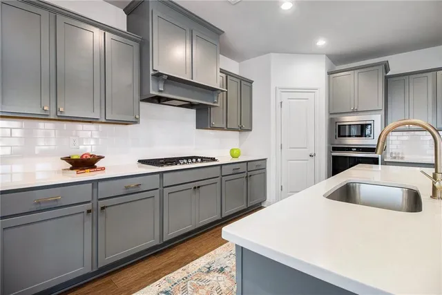 a kitchen with stainless steel appliances granite countertop a sink a stove and refrigerator