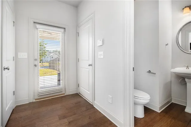 a view of a bathroom with toilet window and wooden floor