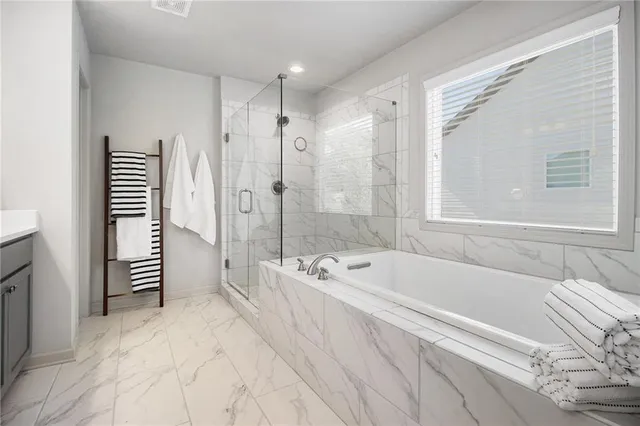 a spacious bathroom with a bathtub and a shower