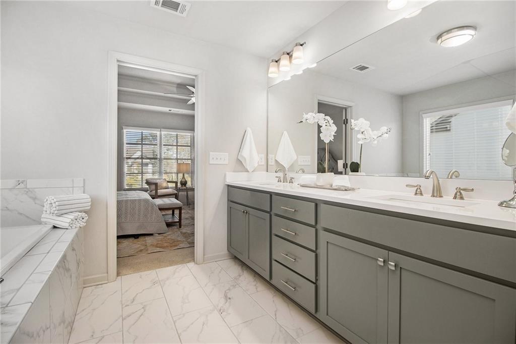 3235 Rockbridge Road Southwest Avondale Estates, GA 30002 - Photo 24 of 37 a en suite bathroom with a double vanity sink a mirror and a bathtub