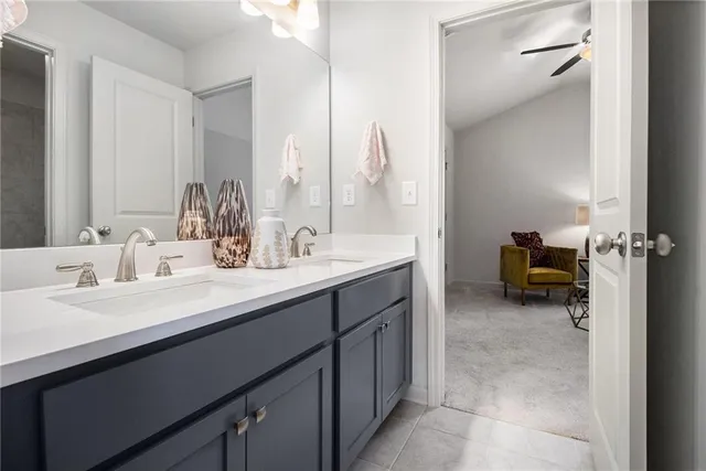 a en suite bathroom with a double vanity sink and a mirror
