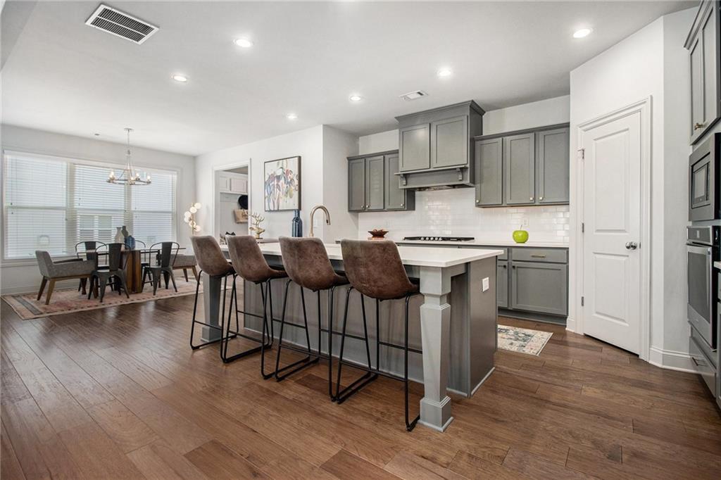 3235 Rockbridge Road Southwest Avondale Estates, GA 30002 - Photo 9 of 37 a open kitchen with stainless steel appliances granite countertop a dining table chairs refrigerator and sink