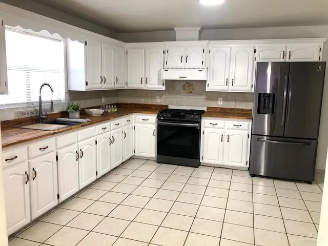 a kitchen with a stove top oven sink and cabinets