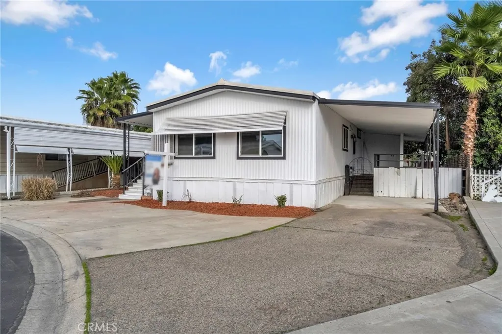 1218 East Cleveland Avenue, Unit 153 Madera, CA 93638 - Photo 2 of 39 a front view of a house with a yard and garage