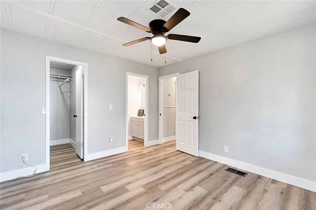 1218 East Cleveland Avenue, Unit 153 Madera, CA 93638 - Photo 21 of 39 an empty room with wooden floor and ceiling fan