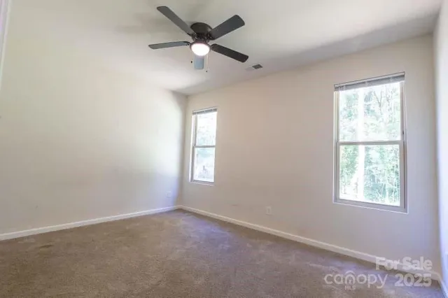 an empty room with a window and a fan
