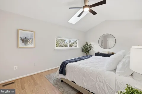a bedroom with bed and a painting on the wall