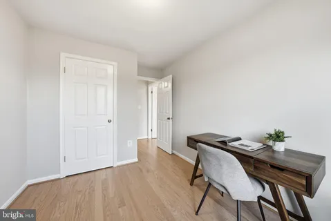 a view of a workspace with furniture and wooden floor