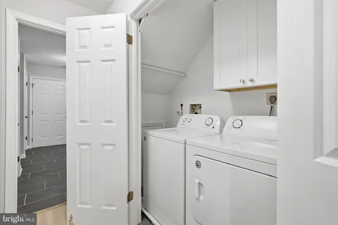 a utility room with cabinets washer and dryer