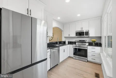 a kitchen with white cabinets and stainless steel appliances