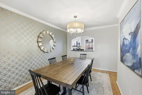 a dining room with wooden floor a table and chairs