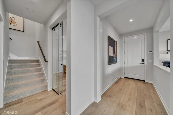 a view of a hallway with wooden floor and staircase