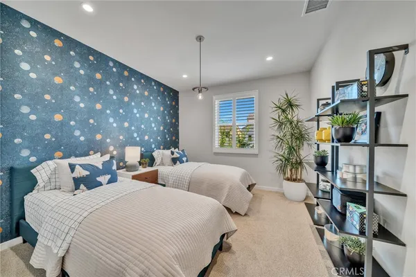 a bedroom with a large bed and a potted plant