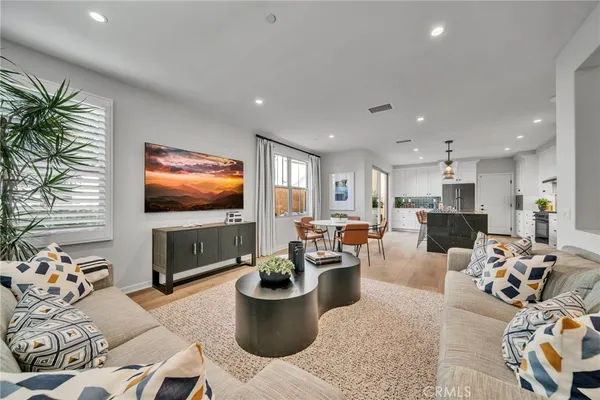 a living room with furniture kitchen view and a flat screen tv