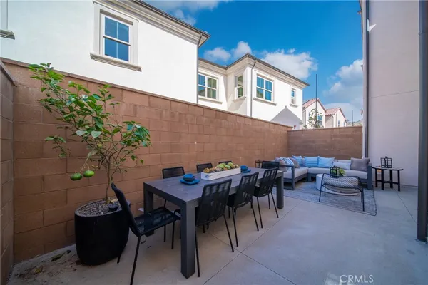 a view of a patio with couple of chairs and a potted plant