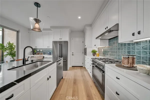 a kitchen with stainless steel appliances a sink stove and refrigerator