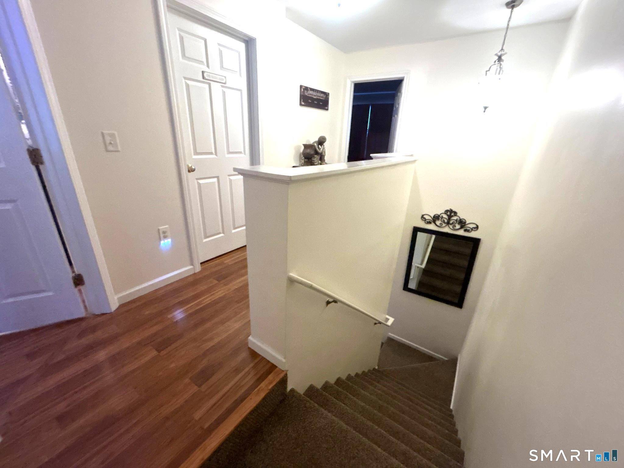 194 Summit Street Norwich, CT 06360 - Photo 9 of 24 a view of a hallway with wooden floor and staircase