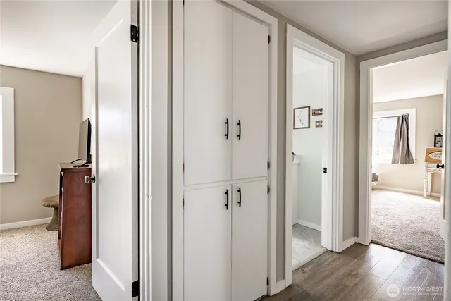 a view of a hallway with wooden floor and closet area