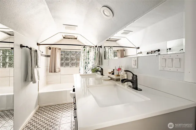 a bathroom with a sink a mirror and a bathtub
